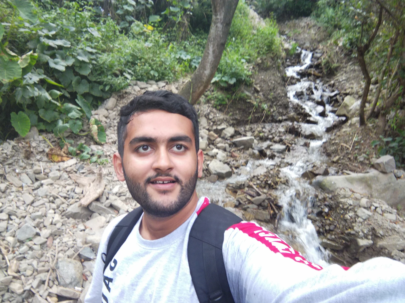 Arnav Kharbanda beside a mountain stream