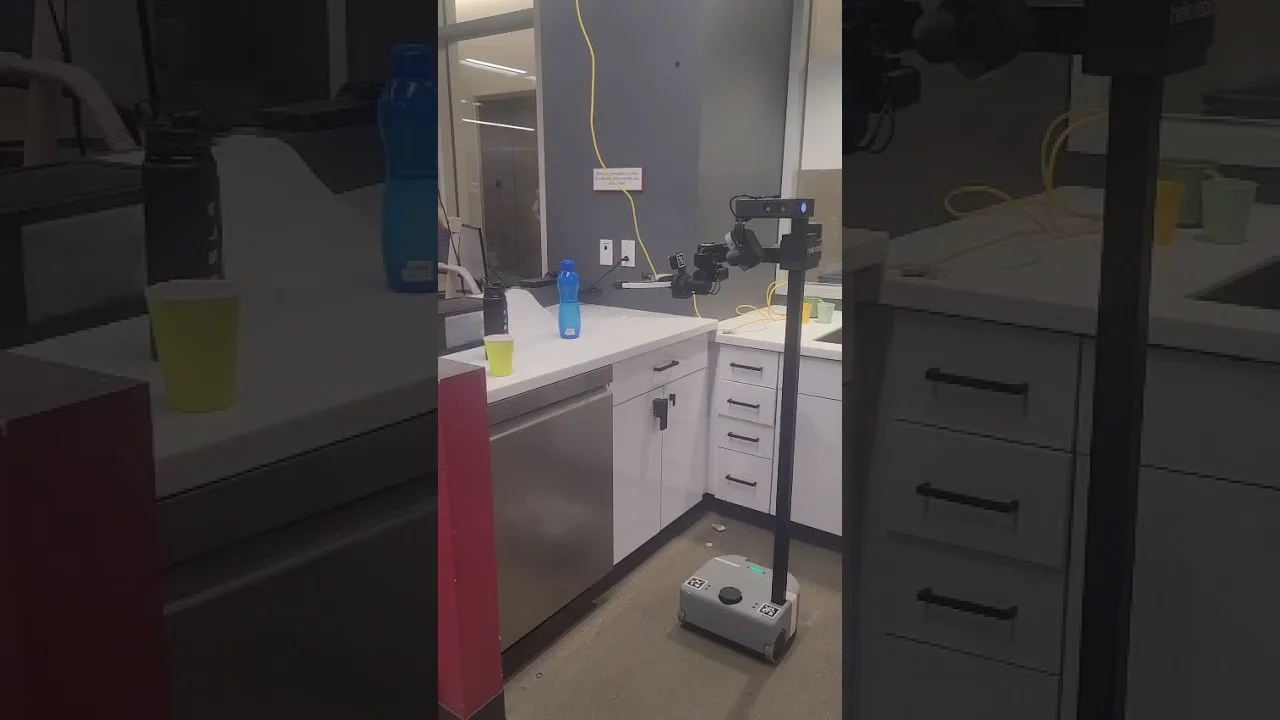 Hello Robot Stretch 3 mobile manipulator reaching toward a cup